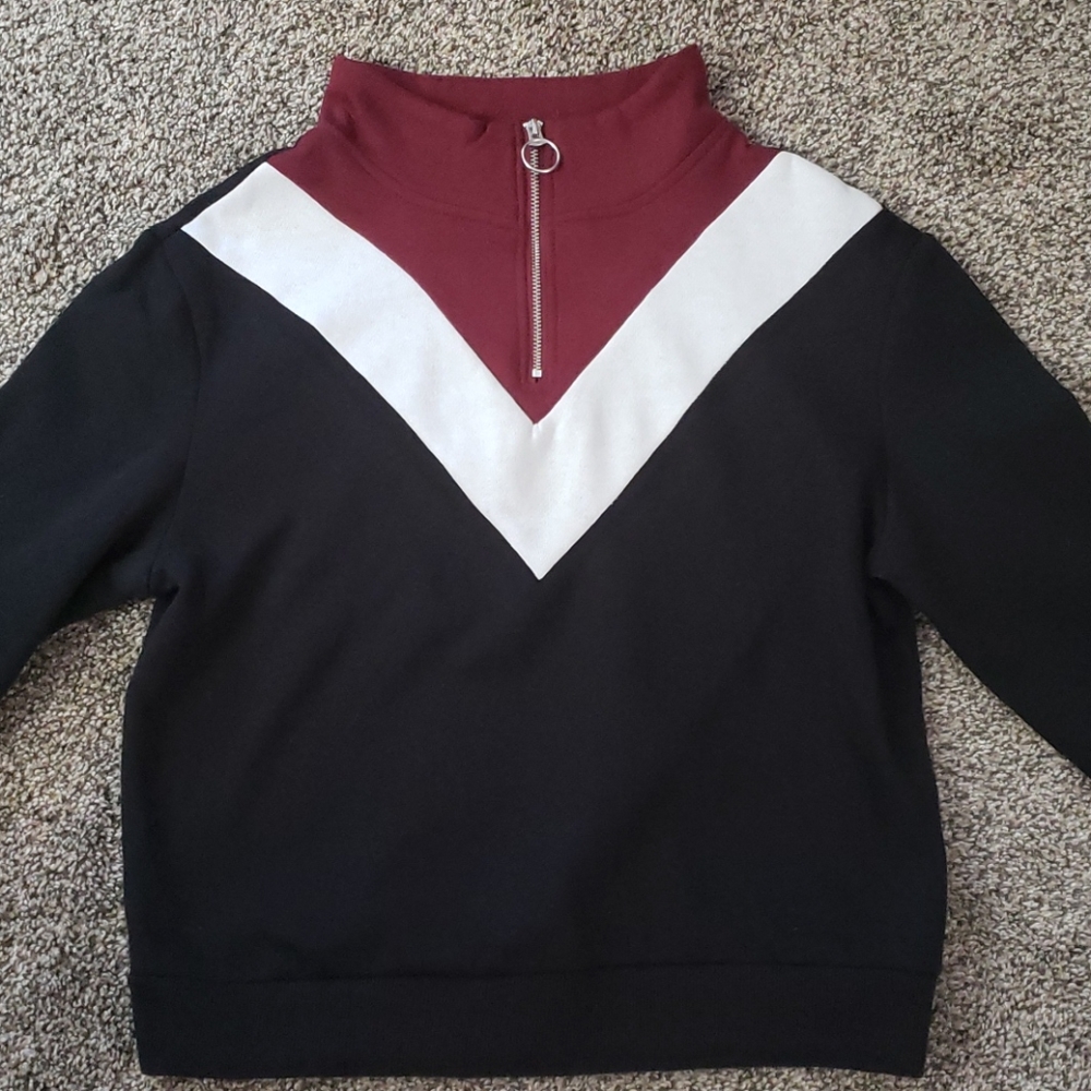 A longer cropped sweater with cuffed sleeves.